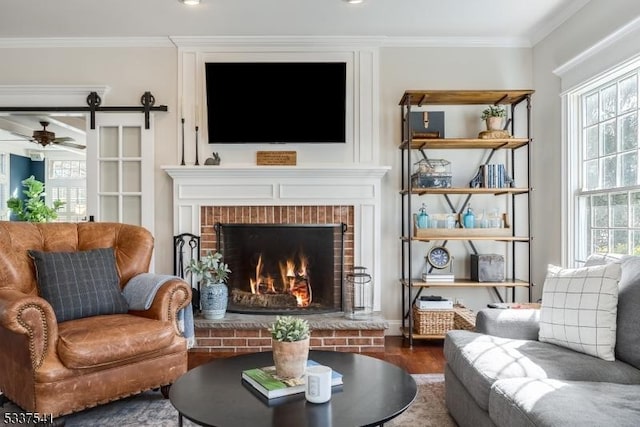 sitting room featuring a healthy amount of sunlight, wood finished floors, and crown molding