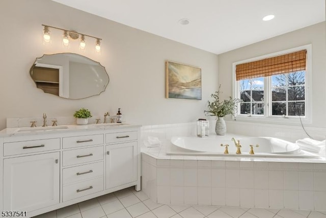 bathroom with a garden tub, double vanity, a sink, and tile patterned floors