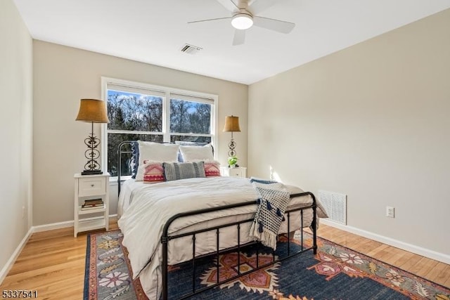 bedroom featuring wood finished floors, visible vents, and baseboards