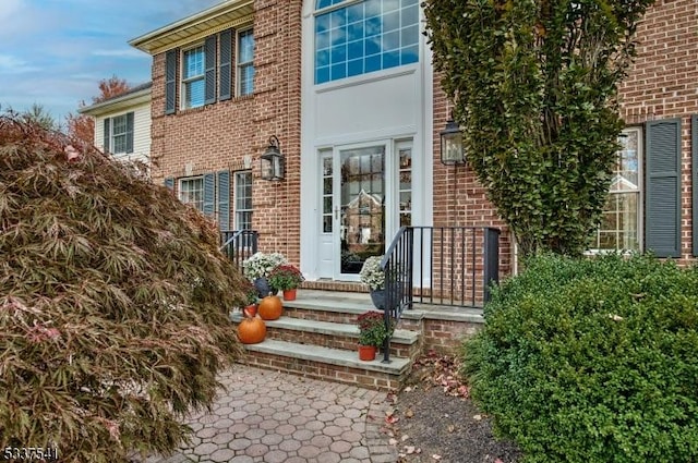 view of exterior entry featuring brick siding