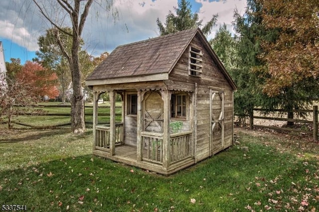 view of outdoor structure featuring fence and an outbuilding