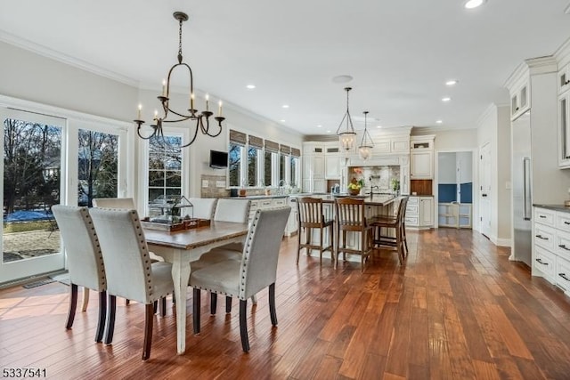 dining area with dark wood-type flooring, recessed lighting, a notable chandelier, and ornamental molding