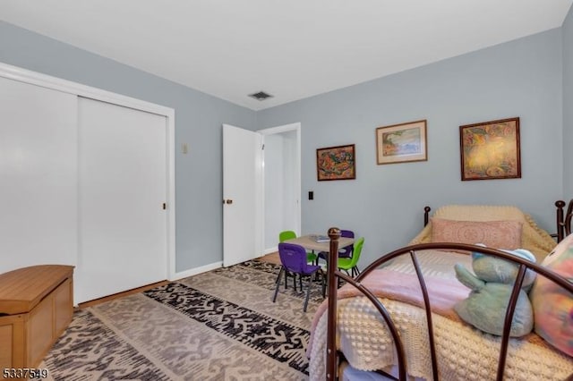 bedroom with a closet, visible vents, and baseboards