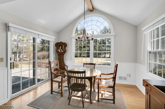 dining area with a chandelier, wainscoting, visible vents, and light wood-style flooring