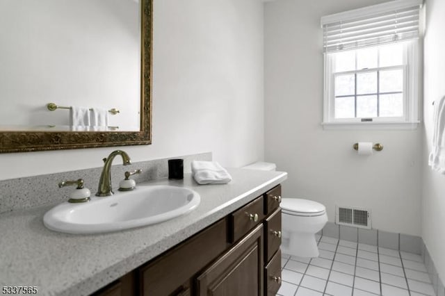 bathroom with toilet, vanity, visible vents, and tile patterned floors