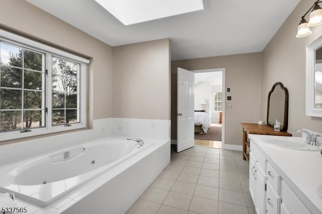 ensuite bathroom with a skylight, tile patterned floors, vanity, ensuite bath, and a bath