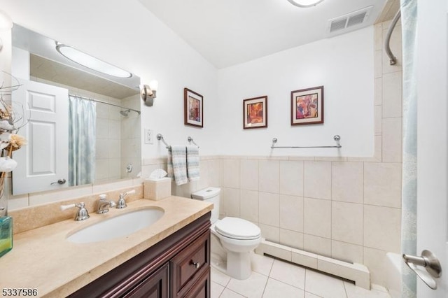 bathroom featuring toilet, tile walls, baseboard heating, vanity, and tile patterned flooring