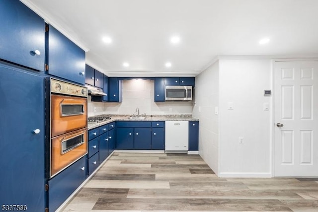 kitchen featuring blue cabinets, appliances with stainless steel finishes, sink, and light wood-type flooring