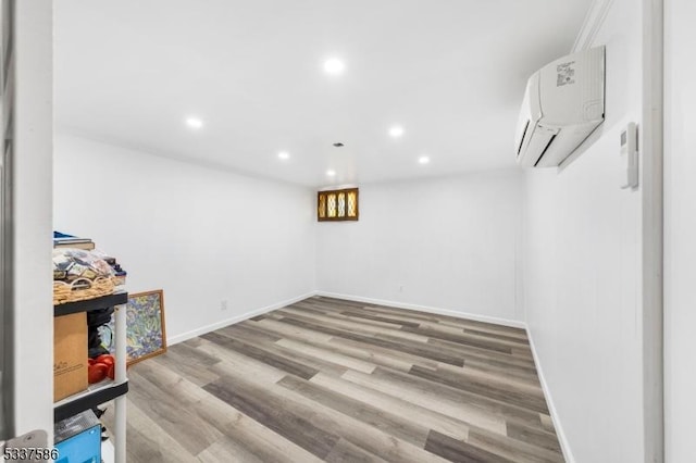 basement featuring wood-type flooring and a wall unit AC