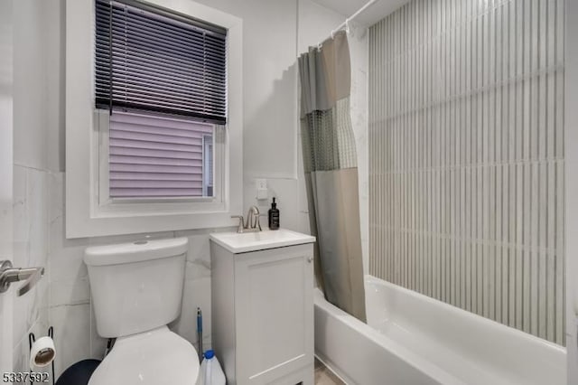 full bathroom with vanity, tile walls, shower / bath combo with shower curtain, and toilet