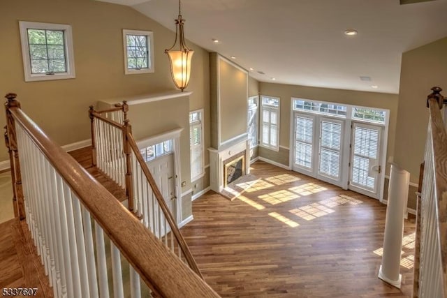 foyer with lofted ceiling, recessed lighting, a high end fireplace, wood finished floors, and baseboards