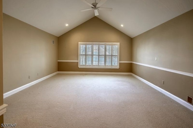 empty room featuring carpet, baseboards, vaulted ceiling, and a ceiling fan