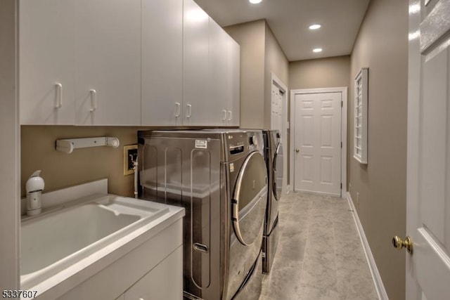 washroom with recessed lighting, cabinet space, a sink, separate washer and dryer, and baseboards