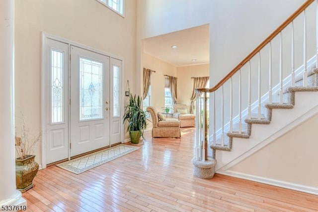 foyer entrance featuring stairway, a high ceiling, and hardwood / wood-style flooring