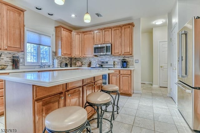 kitchen with backsplash, a kitchen breakfast bar, stainless steel appliances, and light countertops