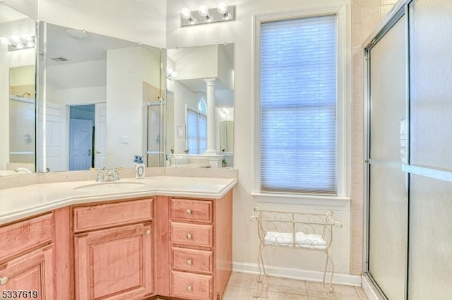 full bath featuring tile patterned floors, a shower stall, and ornate columns