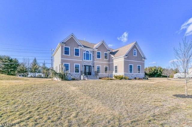 view of front of house featuring stucco siding, stone siding, and a front yard