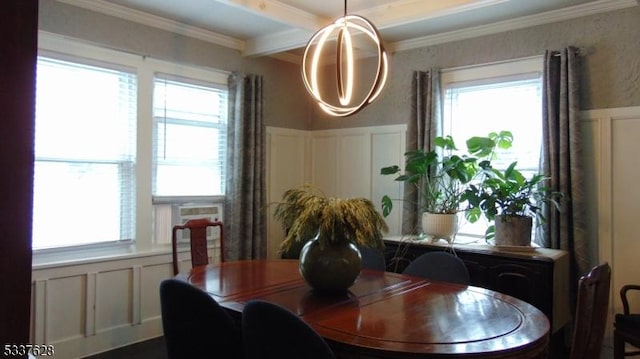 dining room featuring a wealth of natural light, a decorative wall, ornamental molding, and a wainscoted wall