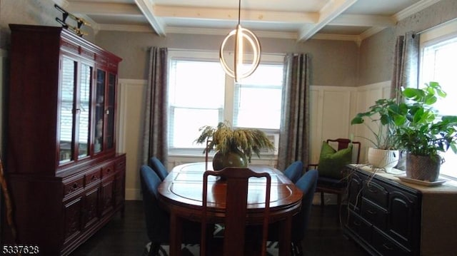 dining room with beam ceiling, coffered ceiling, a wainscoted wall, and a wealth of natural light