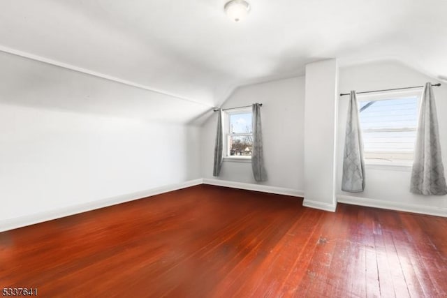 bonus room featuring lofted ceiling and dark hardwood / wood-style flooring