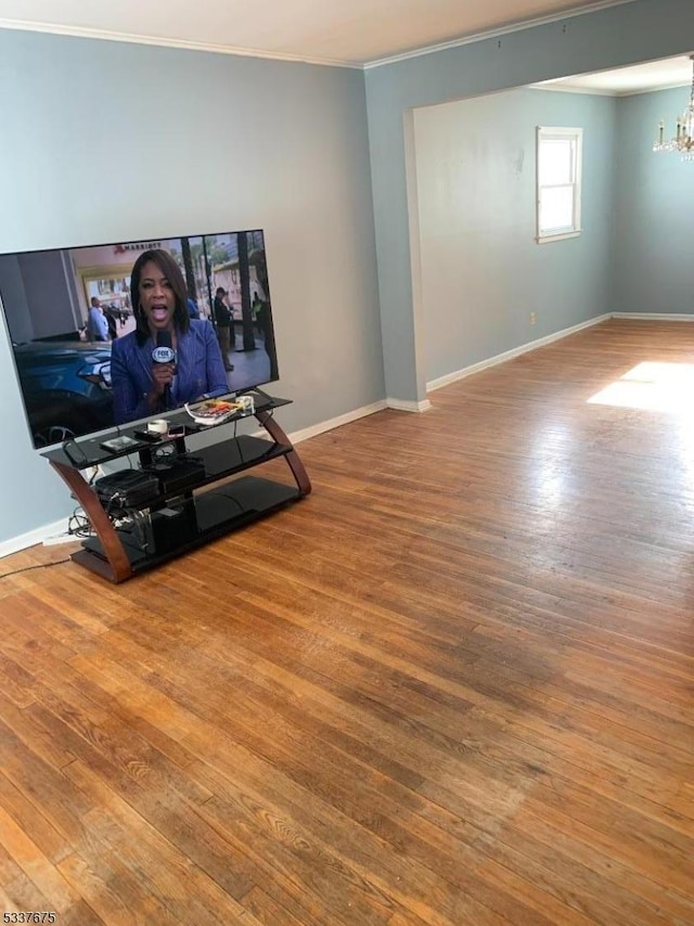 living room featuring ornamental molding, hardwood / wood-style floors, and a notable chandelier