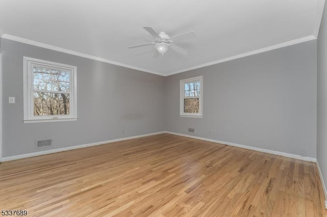 empty room featuring ornamental molding, light wood-style flooring, and baseboards