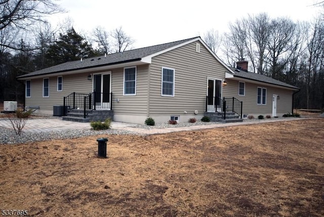 view of front of home featuring a chimney and cooling unit