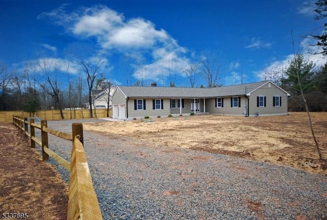 ranch-style home featuring a garage, driveway, fence, and a porch