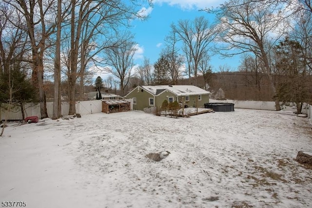 yard layered in snow with a jacuzzi