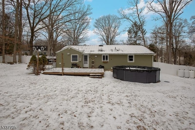 snow covered rear of property with a pool side deck