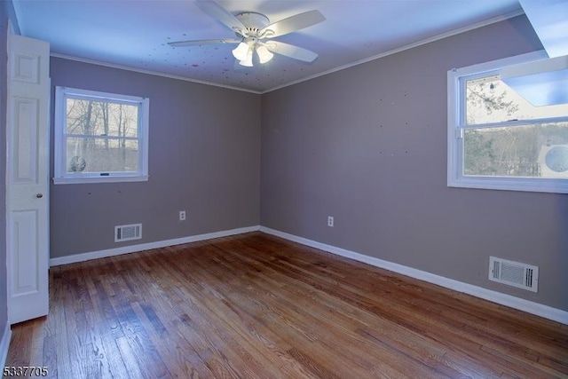 spare room with hardwood / wood-style floors, crown molding, and ceiling fan