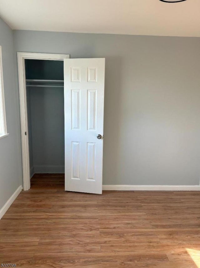 unfurnished bedroom featuring a closet and light wood-type flooring