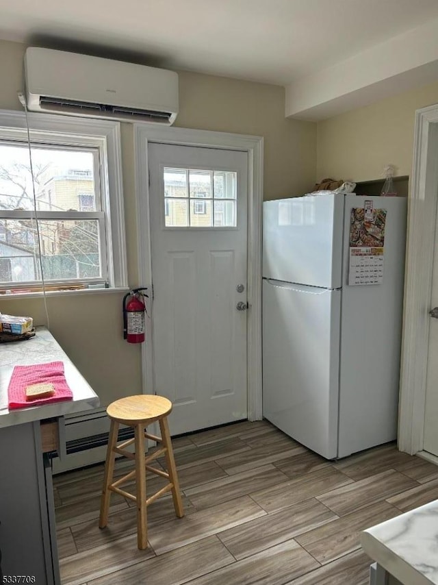 doorway to outside with an AC wall unit and baseboard heating