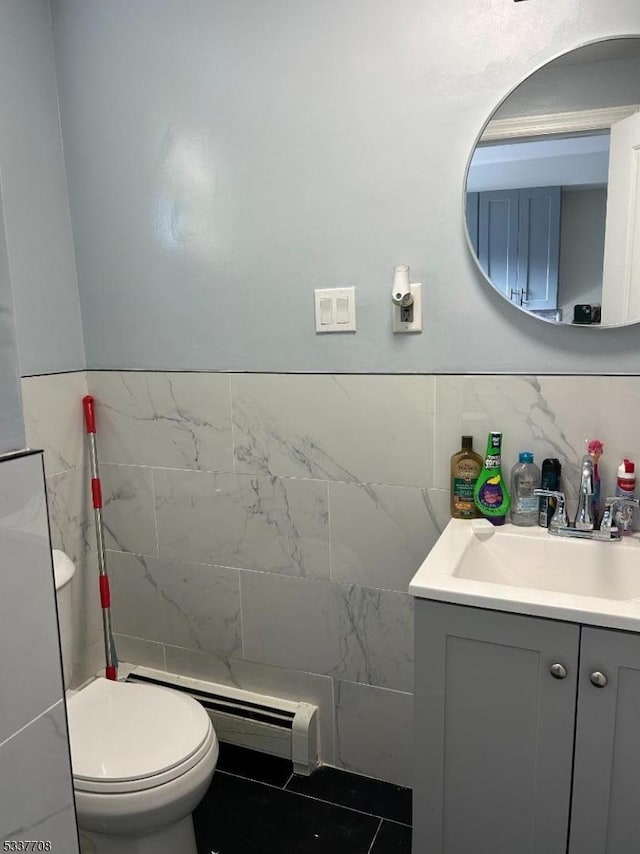 bathroom with vanity, tile walls, a baseboard radiator, and toilet