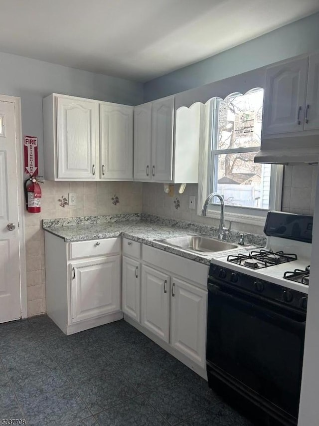 kitchen featuring sink, black gas range, white cabinetry, backsplash, and custom range hood