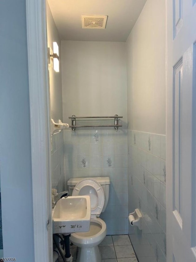 bathroom with tile patterned flooring, sink, tile walls, and toilet