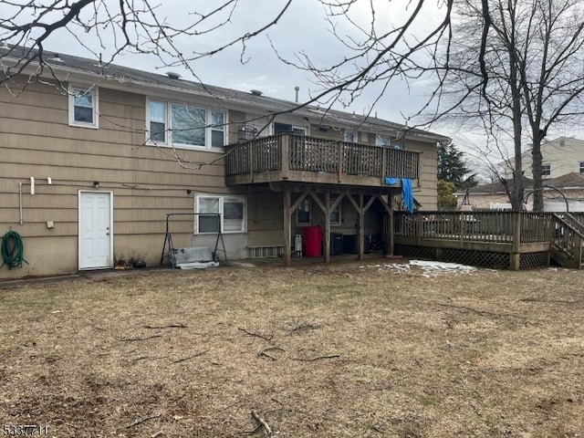 rear view of property featuring a deck and a yard