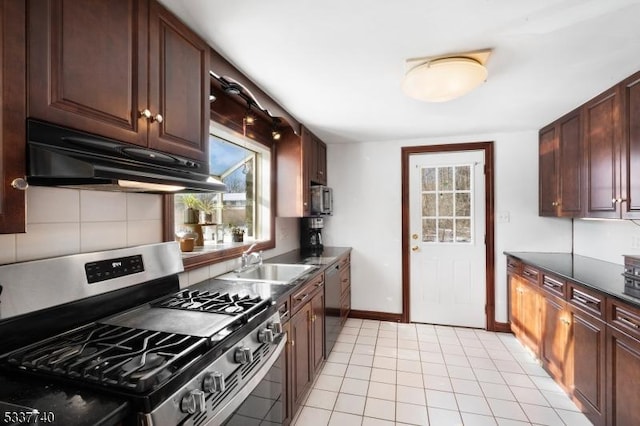 kitchen with stainless steel appliances, dark countertops, tasteful backsplash, a sink, and under cabinet range hood