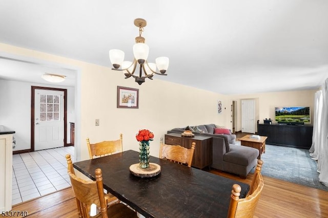 dining space featuring light wood-style floors and a notable chandelier