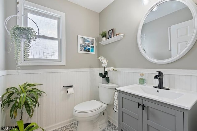 bathroom featuring a wainscoted wall, vanity, and toilet