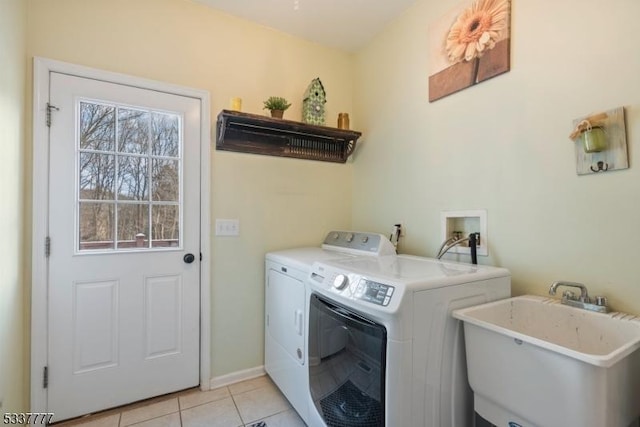 laundry area with laundry area, light tile patterned flooring, a sink, and washer and clothes dryer