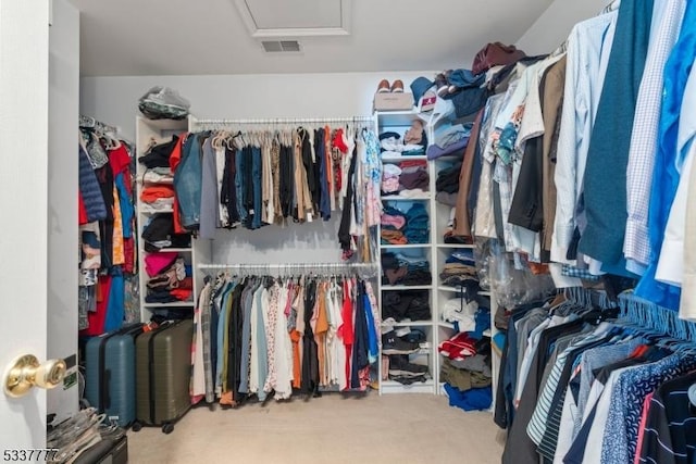 spacious closet featuring attic access, visible vents, and carpet floors