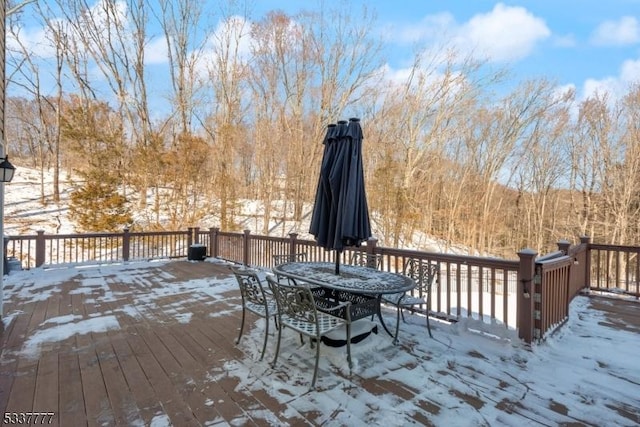 snow covered deck featuring outdoor dining area