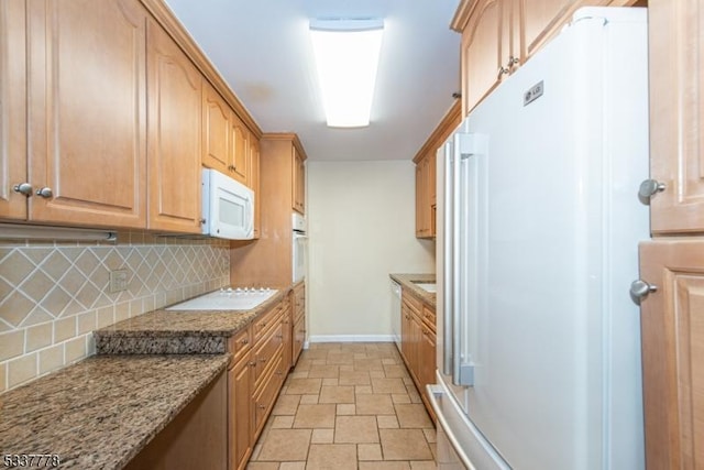 kitchen featuring backsplash, white appliances, and light stone countertops