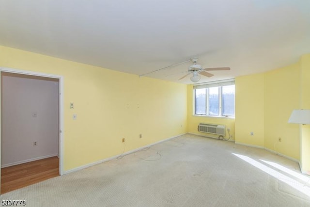 empty room with a wall mounted air conditioner, light colored carpet, and ceiling fan