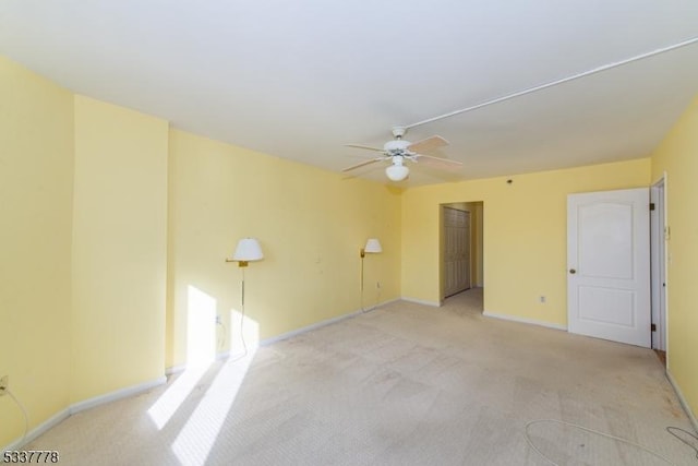 unfurnished room with ceiling fan and light colored carpet