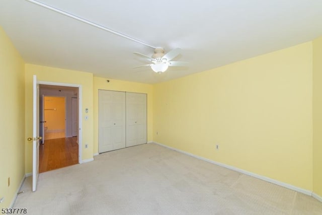 unfurnished bedroom with ceiling fan, a closet, and carpet