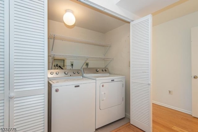 laundry area featuring washer and clothes dryer and light hardwood / wood-style floors