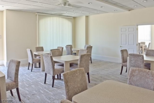 dining room featuring light colored carpet and a drop ceiling