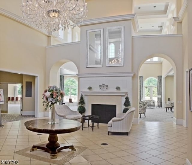 common area featuring light tile patterned flooring, a towering ceiling, and ornamental molding